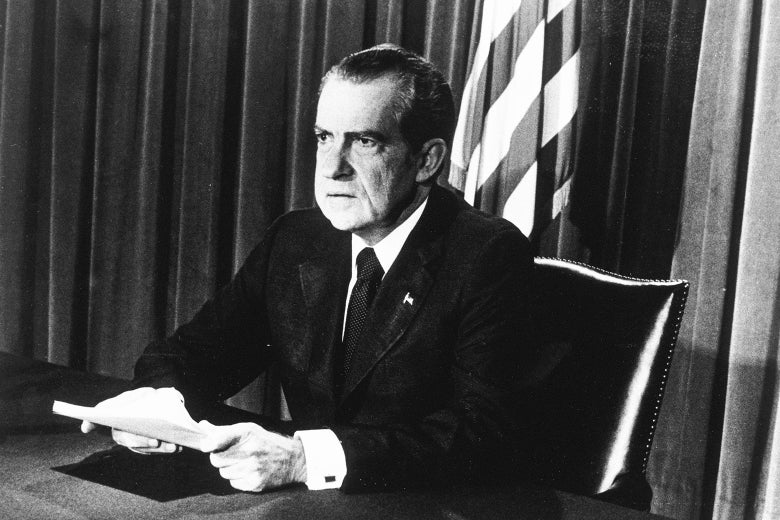 U.S. President Richard M. Nixon sits at a desk, holding papers, as he announces his resignation on television, Washington, D.C.